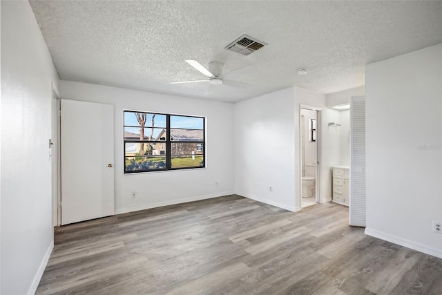 unfurnished room with a textured ceiling, hardwood / wood-style flooring, and ceiling fan