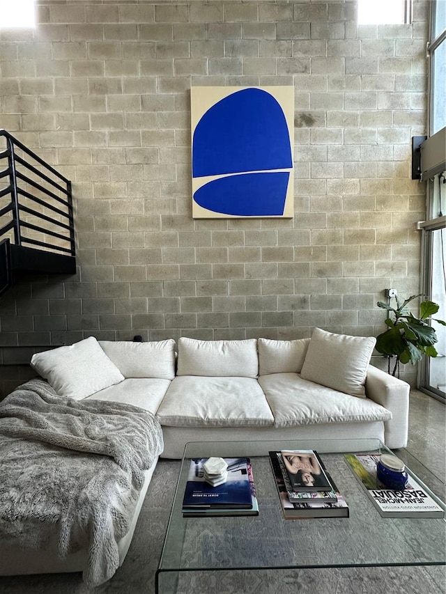 living room with a healthy amount of sunlight and brick wall