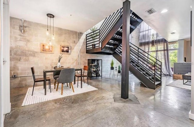 interior space featuring recessed lighting, concrete floors, visible vents, stairway, and concrete block wall