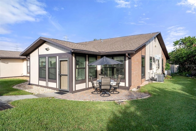 back of property with central air condition unit, a patio area, and a yard