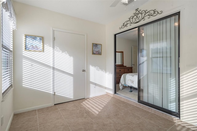 unfurnished bedroom featuring ceiling fan, light tile patterned floors, and a closet