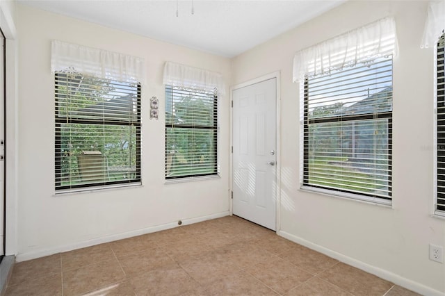 tiled empty room with a healthy amount of sunlight