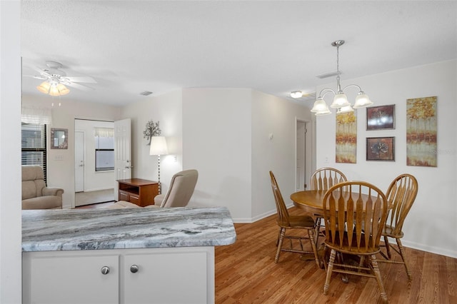 dining space with ceiling fan and light hardwood / wood-style flooring