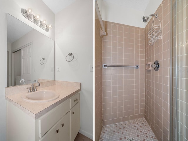 bathroom featuring vanity, tile patterned floors, and a tile shower