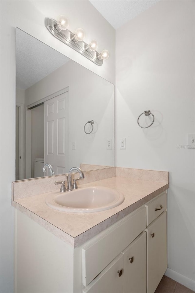 bathroom featuring tile patterned flooring, vanity, and a textured ceiling