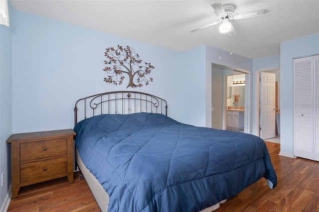 bedroom featuring hardwood / wood-style flooring, a textured ceiling, connected bathroom, ceiling fan, and a closet