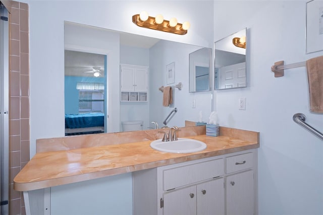 bathroom with toilet, vanity, and ceiling fan