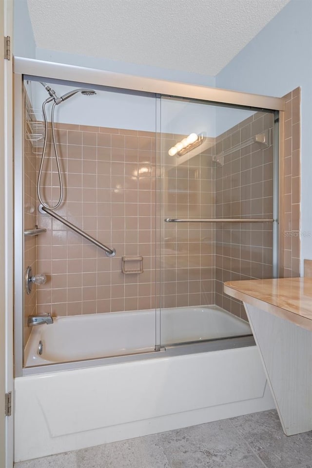 bathroom with enclosed tub / shower combo and a textured ceiling