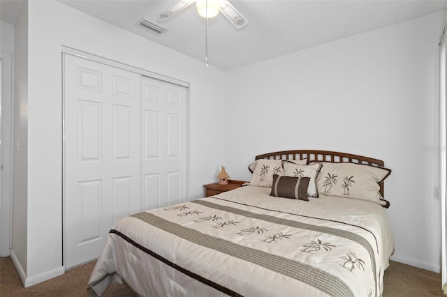 carpeted bedroom featuring a closet, a textured ceiling, and ceiling fan