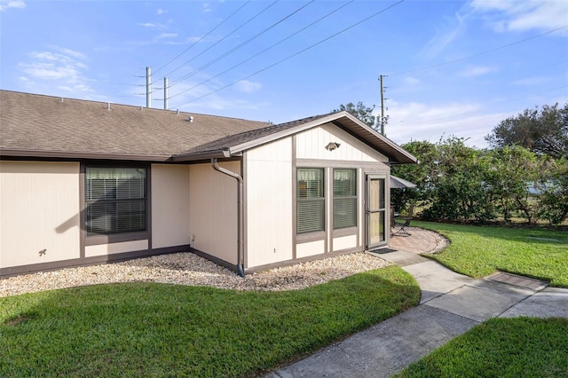 view of side of home with a yard