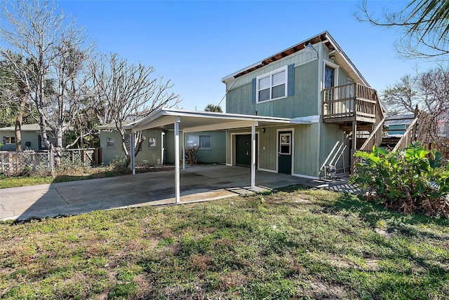 back of property with a carport and a yard