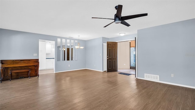 unfurnished living room featuring wood-type flooring and ceiling fan with notable chandelier