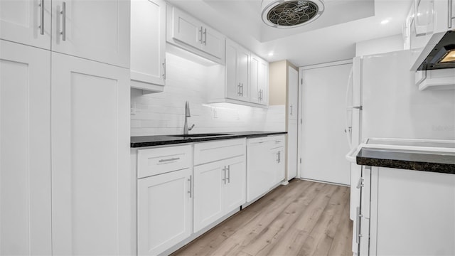3499 Cedar Ln, Palm Harbor, FL 34684 - kitchen featuring a sink, white cabinetry, light wood-style floors, dark countertops, and recessed lighting