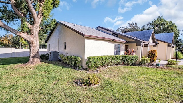 view of property exterior featuring central AC unit and a lawn