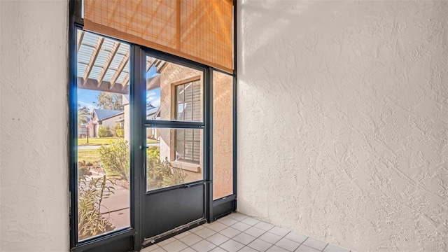 3499 Cedar Ln, Palm Harbor, FL 34684 - doorway to outside featuring a textured wall and light tile patterned floors