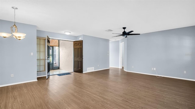 3499 Cedar Ln, Palm Harbor, FL 34684 - empty room featuring a chandelier, dark wood-style flooring, baseboards, and a ceiling fan