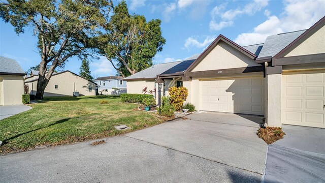 3499 Cedar Ln, Palm Harbor, FL 34684 - view of front of home with stucco siding, driveway, a front yard, and a garage