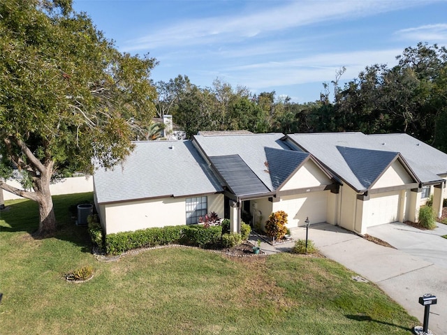 3499 Cedar Ln, Palm Harbor, FL 34684 - view of front of house with a front yard, cooling unit, concrete driveway, an attached garage, and stucco siding