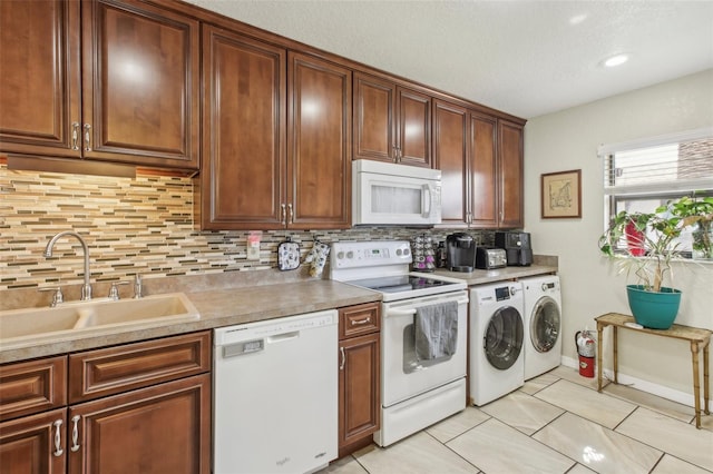 kitchen featuring sink, backsplash, white appliances, washer and clothes dryer, and light tile patterned flooring