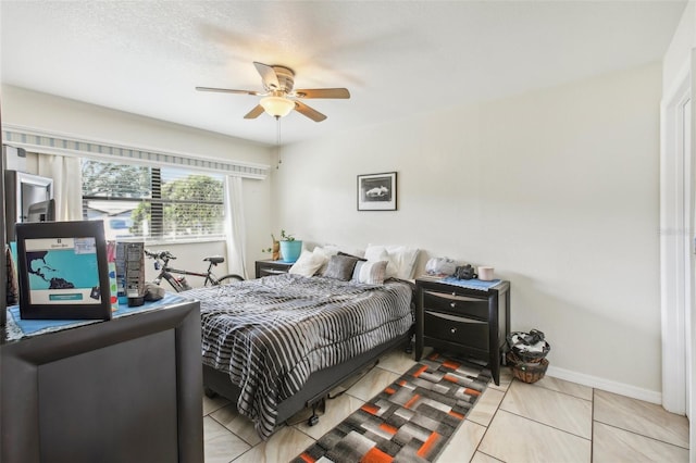 tiled bedroom with ceiling fan and a textured ceiling