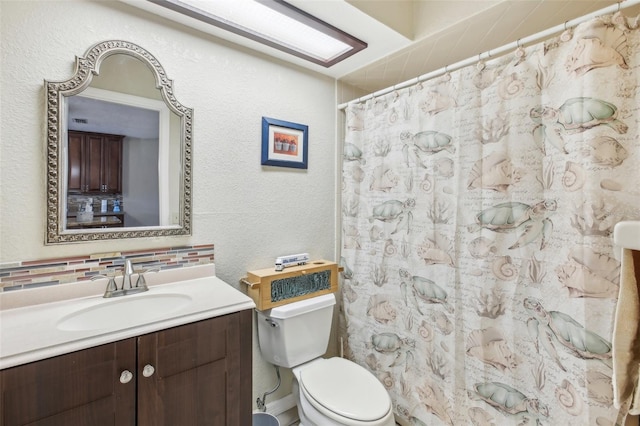 bathroom with decorative backsplash, vanity, toilet, and walk in shower