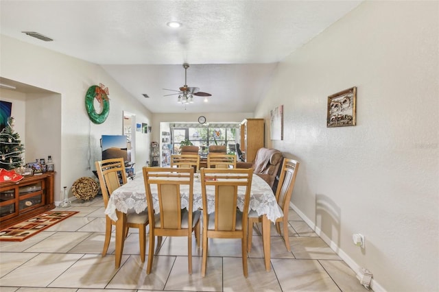 dining room with ceiling fan, light tile patterned floors, a textured ceiling, and vaulted ceiling