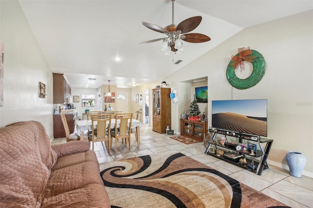 living room featuring lofted ceiling, ceiling fan, and light tile patterned floors