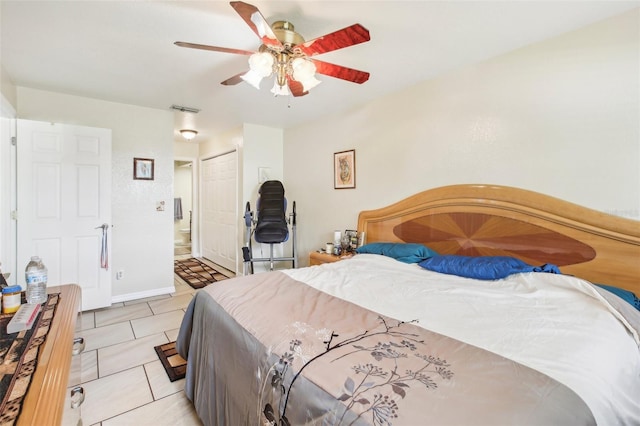 bedroom with ceiling fan, light tile patterned flooring, and a closet