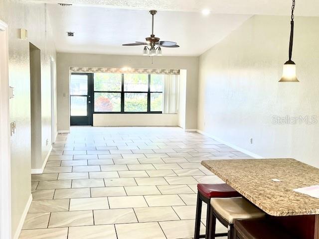 interior space with ceiling fan