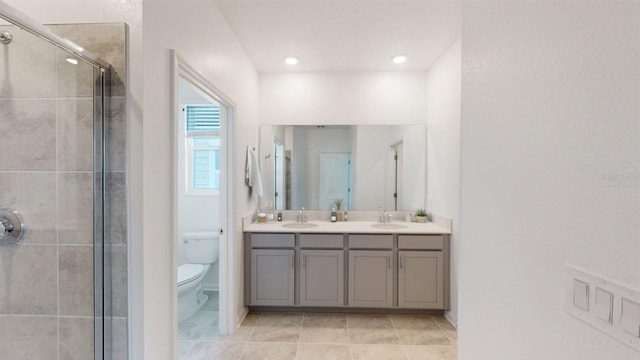 bathroom with walk in shower, vanity, tile patterned floors, and toilet