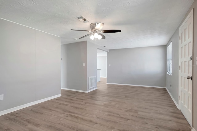 spare room with ceiling fan, a textured ceiling, and light hardwood / wood-style flooring