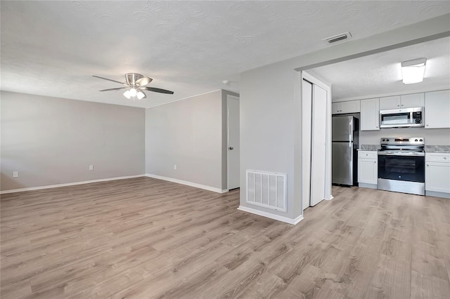 unfurnished living room featuring light hardwood / wood-style flooring, a textured ceiling, and ceiling fan