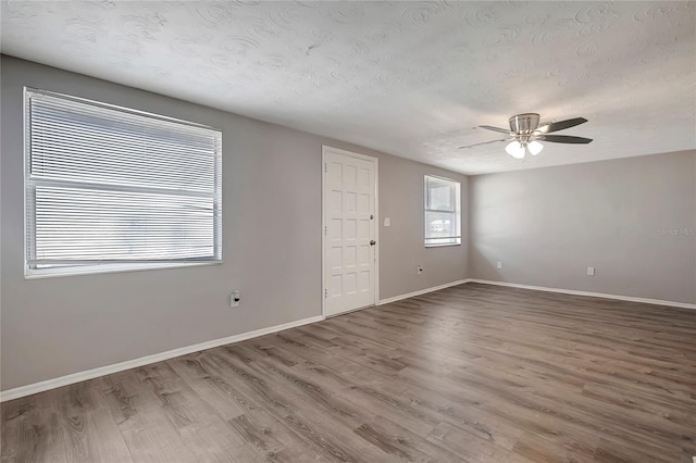 unfurnished room featuring hardwood / wood-style floors, a textured ceiling, and ceiling fan