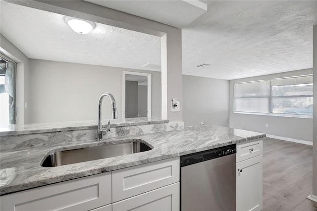 kitchen with dishwasher, a wealth of natural light, sink, and white cabinets