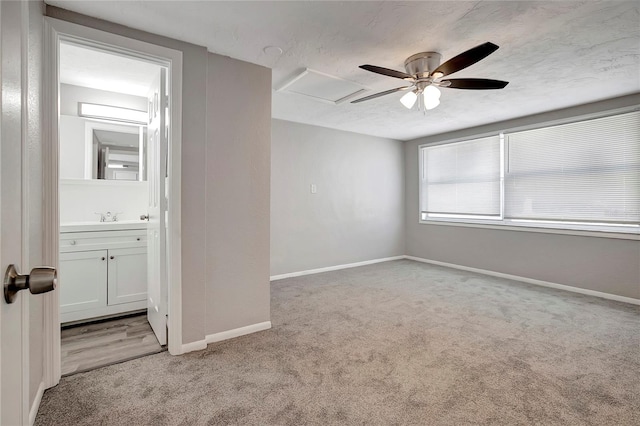 carpeted empty room featuring sink, ceiling fan, and a textured ceiling