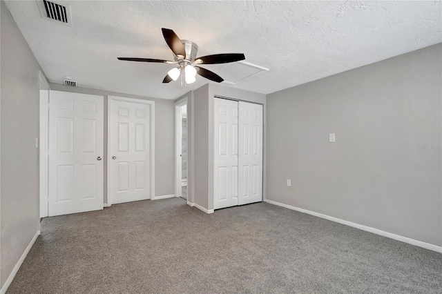 unfurnished bedroom featuring a textured ceiling, carpet flooring, and ceiling fan