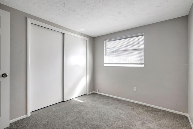 unfurnished bedroom with a closet, carpet, and a textured ceiling