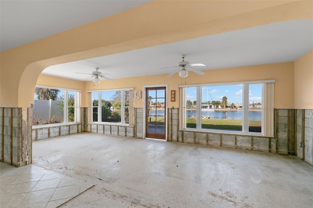 interior space with a water view and ceiling fan