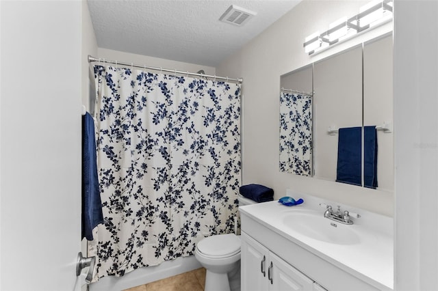 full bathroom featuring toilet, a textured ceiling, shower / tub combo with curtain, tile patterned floors, and vanity