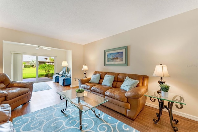 living room with ceiling fan and wood-type flooring