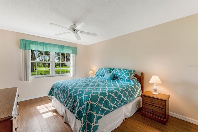 bedroom with wood-type flooring, a textured ceiling, and ceiling fan