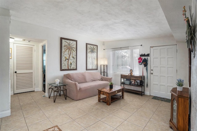 living room with a textured ceiling and light tile patterned floors