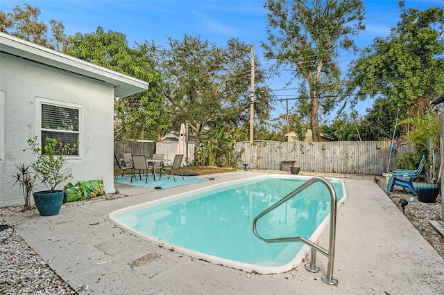 view of pool with a shed and a patio