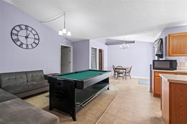 rec room with a chandelier, a textured ceiling, vaulted ceiling, and billiards