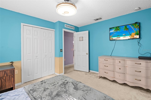 bedroom featuring light carpet, a closet, and a textured ceiling