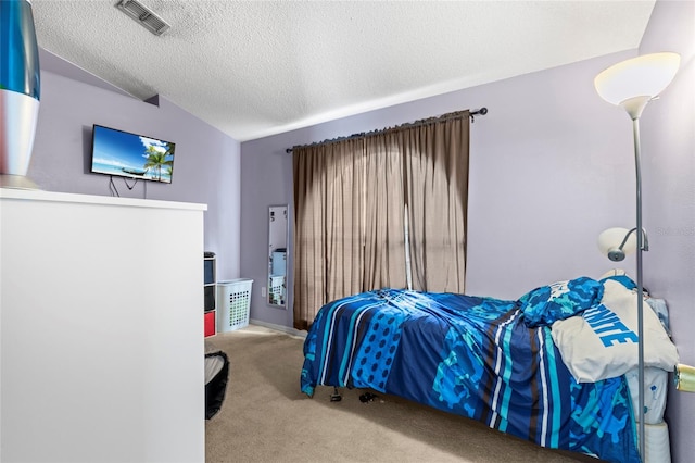 carpeted bedroom with a textured ceiling and vaulted ceiling