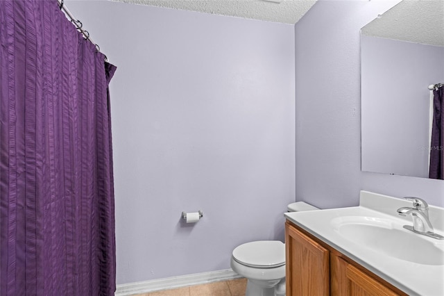 bathroom featuring tile patterned flooring, vanity, a textured ceiling, and toilet