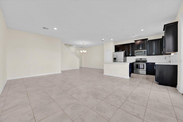 kitchen with a notable chandelier, sink, light tile patterned floors, and stainless steel appliances