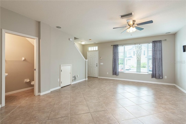 empty room with ceiling fan and light tile patterned floors