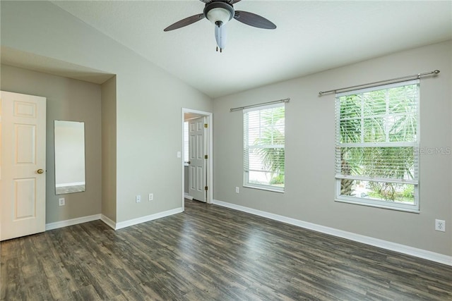 spare room with ceiling fan, dark wood-type flooring, and vaulted ceiling